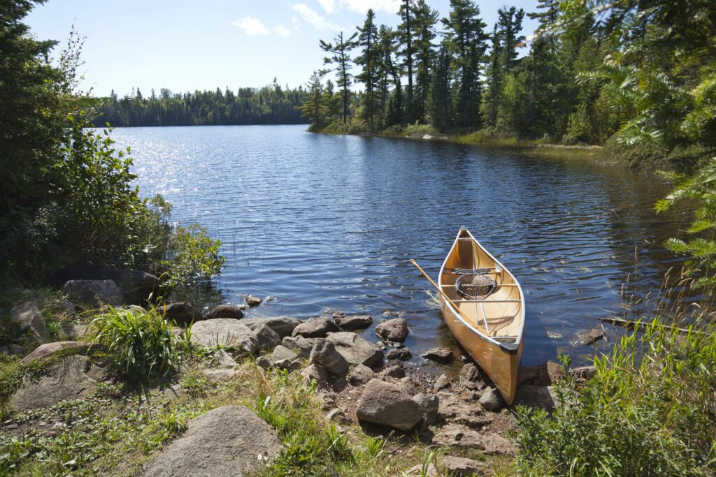 canoe resting on the shore of a serene lake