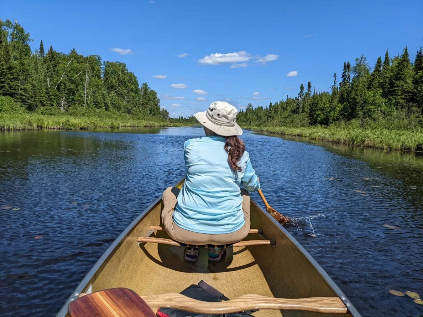 woman in the front of a canoe paddling